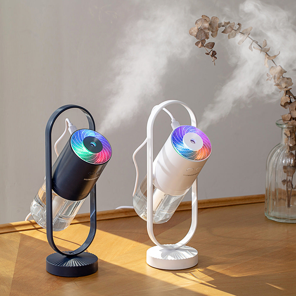 Aurora projection humidifier in navy and white, running on a wooden table