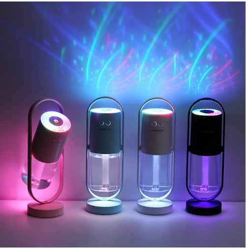 Four Aurora humidifiers casting coloured light across a dark wall